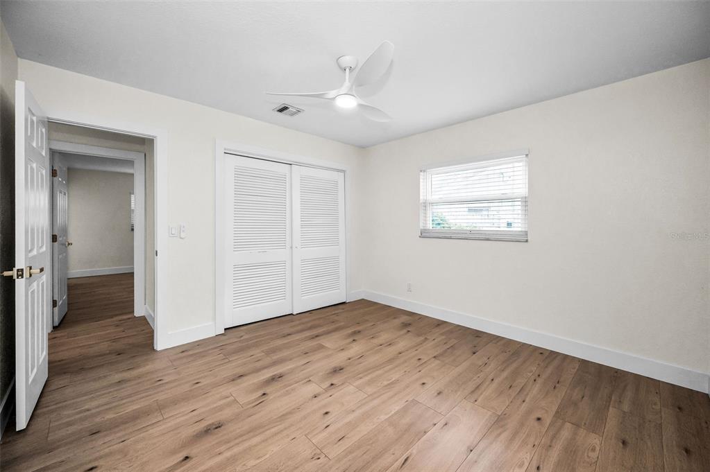 409 Barbara Lane Tampa, FL 33609 - Photo 43 of 51 an empty room with wooden floor cabinet and windows