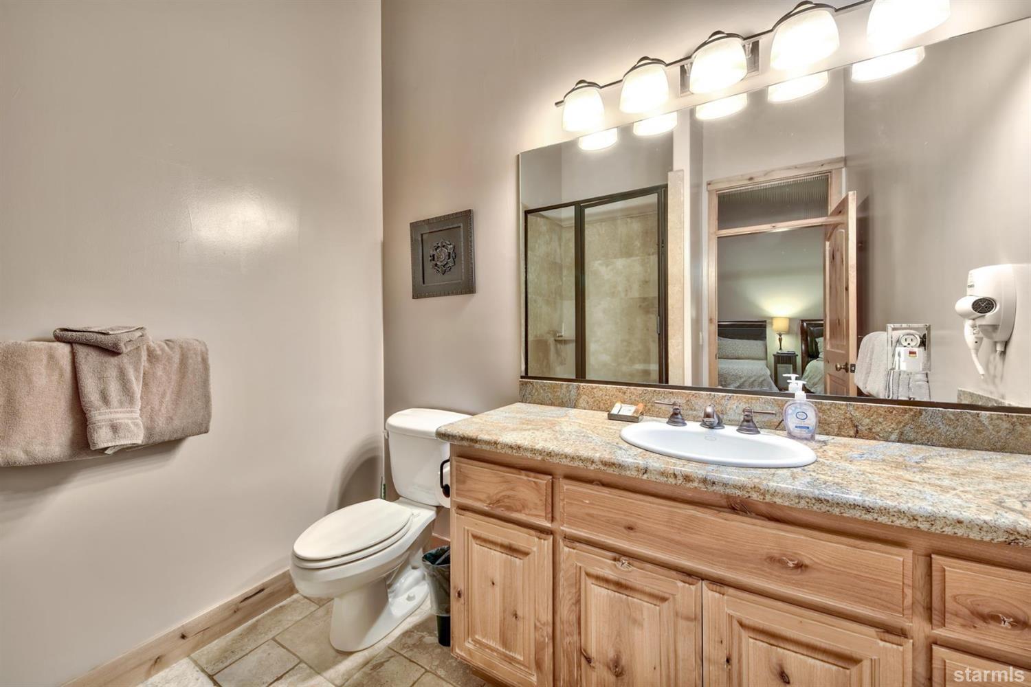 3639 Saddle Road South Lake Tahoe, CA 96150 - Photo 21 of 25 a bathroom with a granite countertop sink mirror vanity and toilet