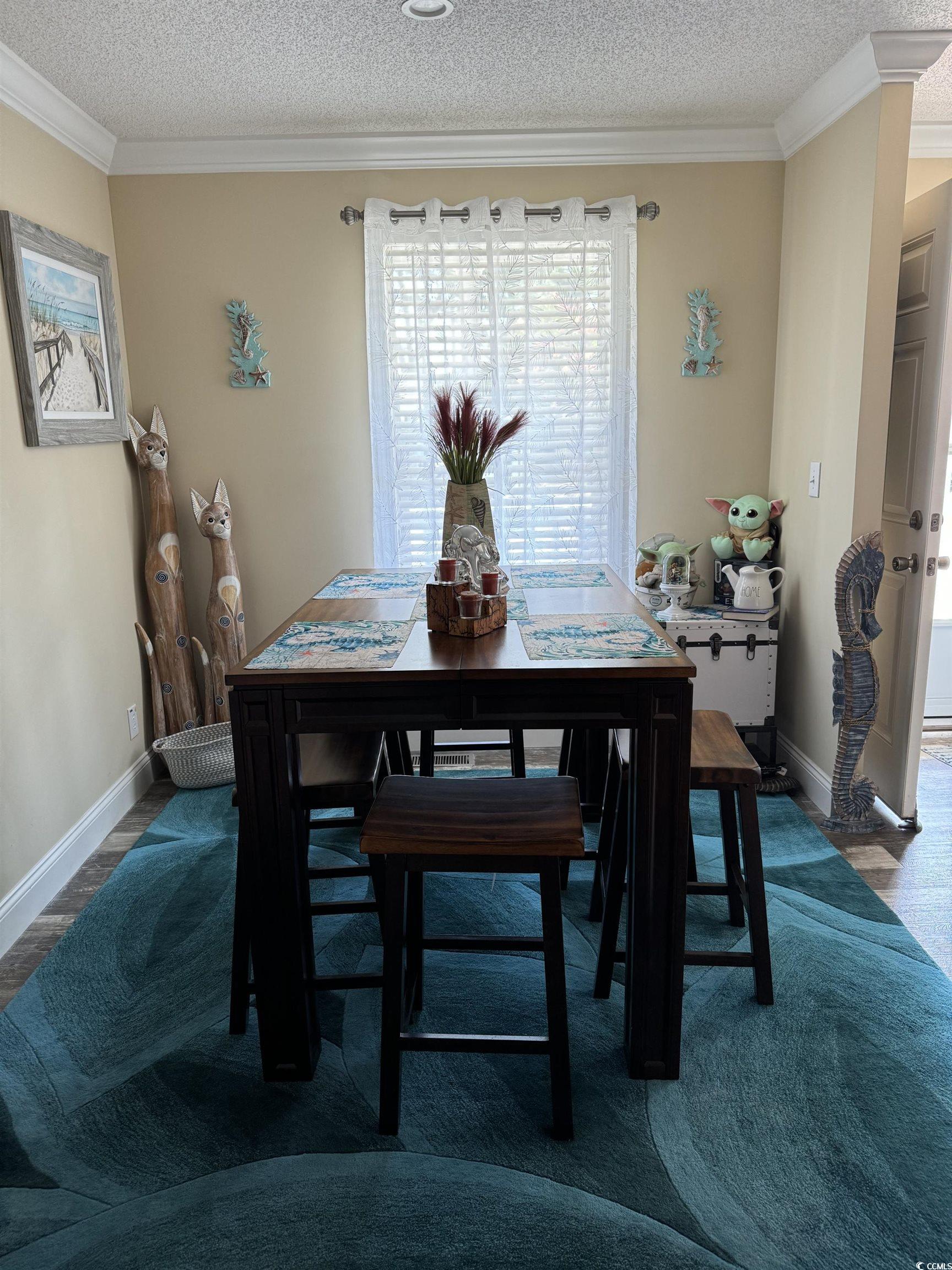 1651 Perry Circle Myrtle Beach, SC 29577 - Photo 11 of 32 Dining area with a textured ceiling, ornamental molding, and dark wood finished floors