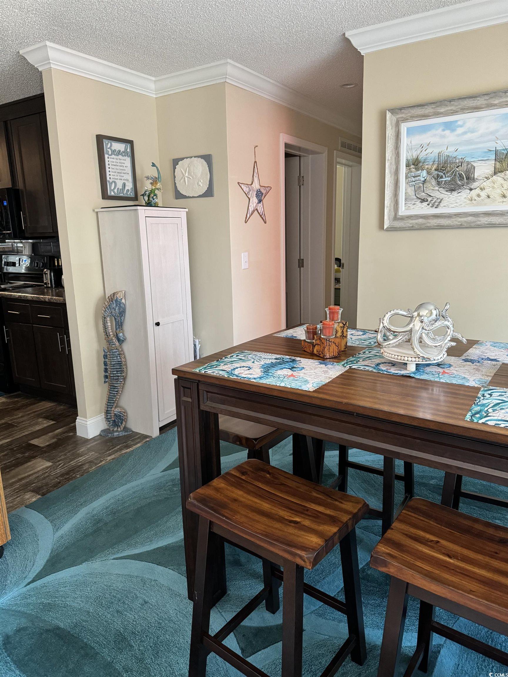 1651 Perry Circle Myrtle Beach, SC 29577 - Photo 12 of 32 Dining space with a textured ceiling, crown molding, and dark wood-style flooring