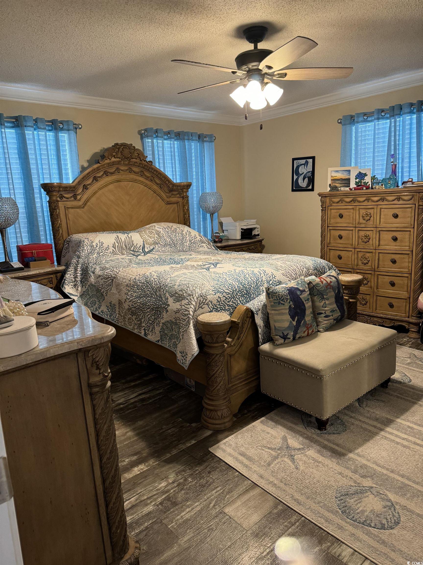 1651 Perry Circle Myrtle Beach, SC 29577 - Photo 17 of 32 Bedroom featuring a textured ceiling, crown molding, dark wood-style flooring, and a ceiling fan