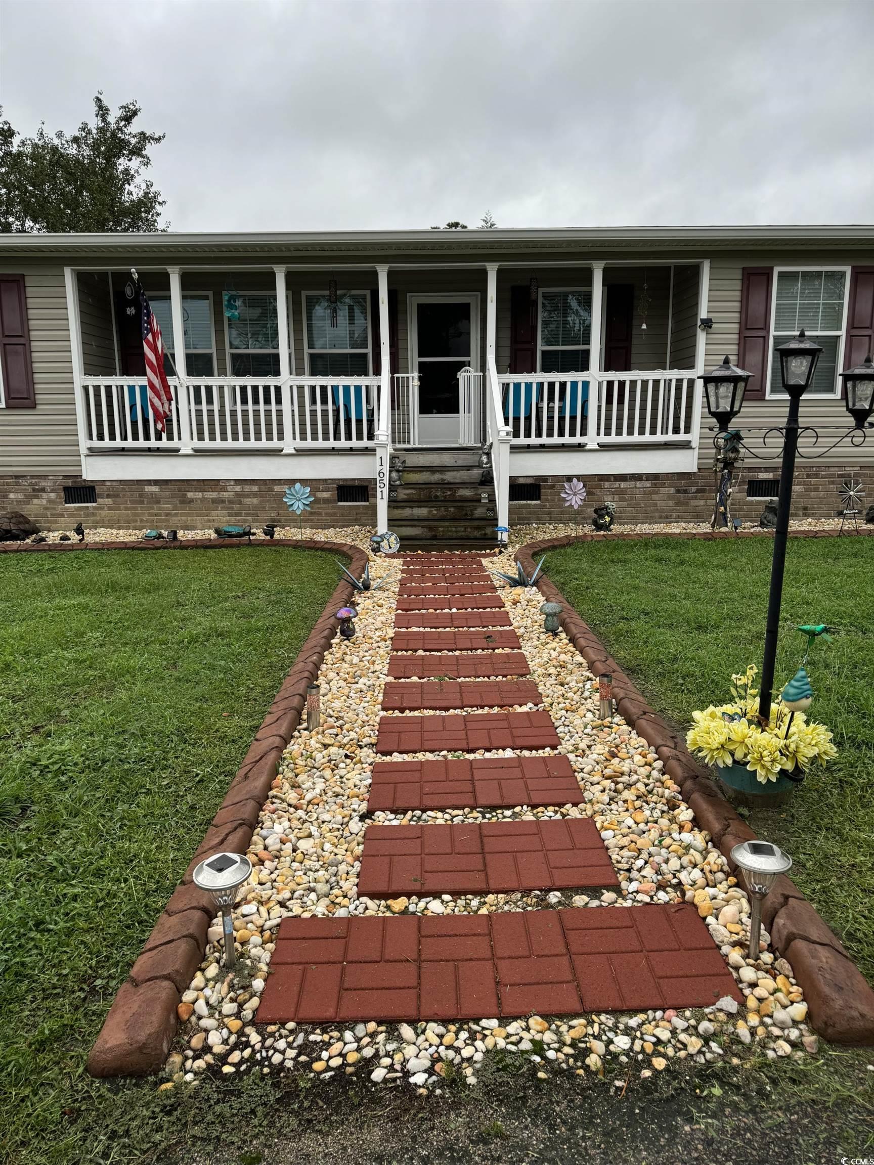 1651 Perry Circle Myrtle Beach, SC 29577 - Photo 2 of 32 View of front facade featuring covered porch, a front yard, and crawl space