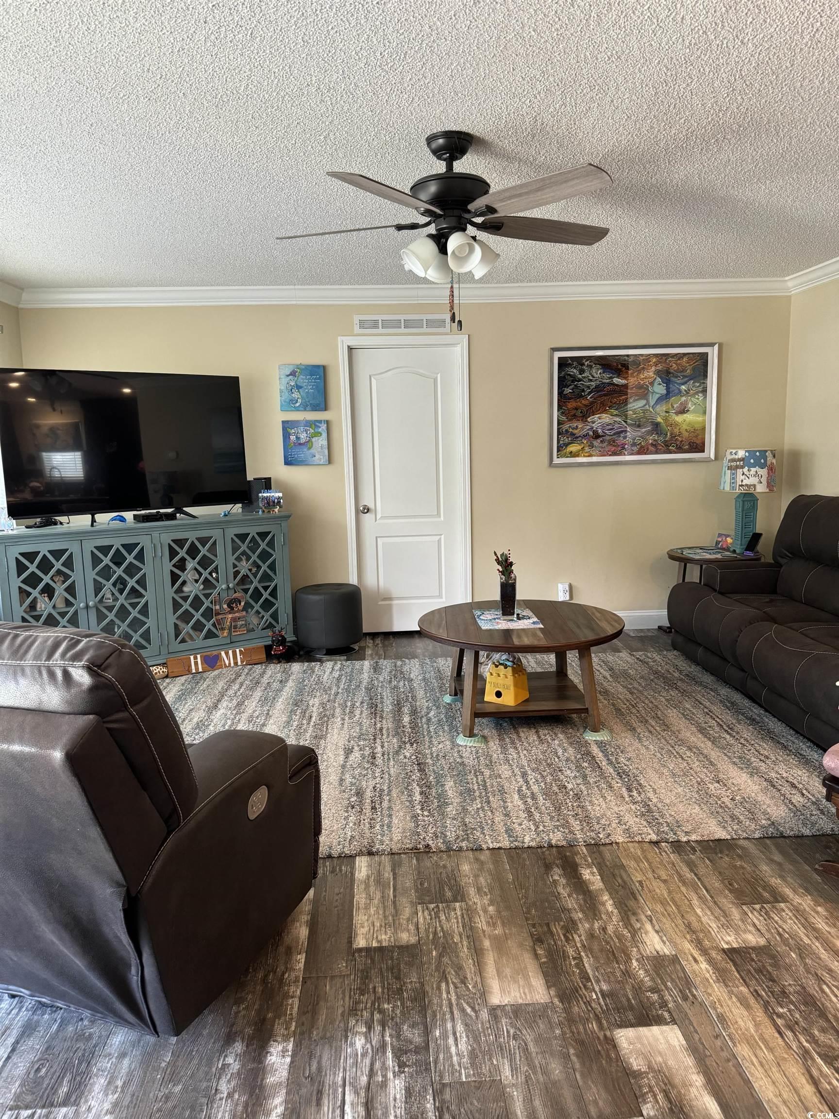 1651 Perry Circle Myrtle Beach, SC 29577 - Photo 7 of 32 Living area with ornamental molding, hardwood / wood-style floors, ceiling fan, and a textured ceiling