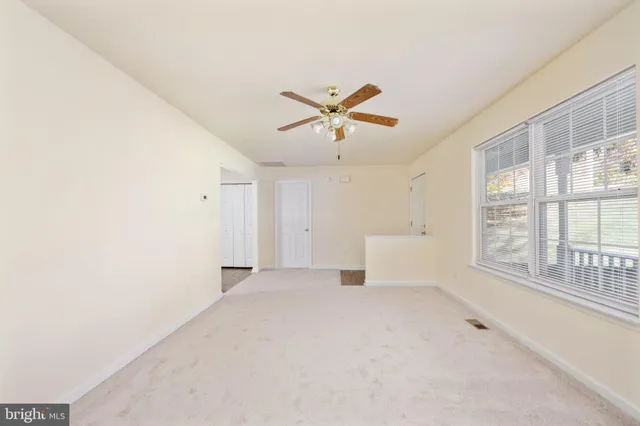 a kitchen with granite countertop a refrigerator a sink dishwasher a stove and white cabinets with wooden floor