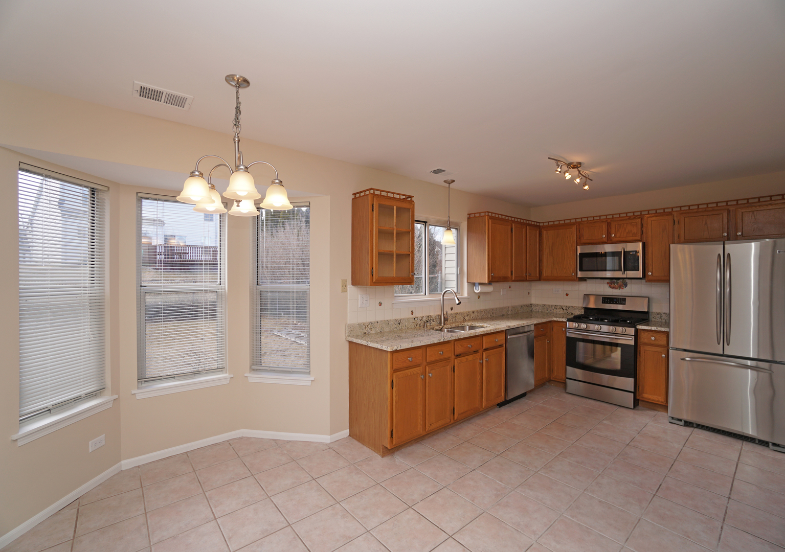 86 Bradford Lane Mundelein, IL 60060 - Photo 6 of 21 a kitchen with stainless steel appliances granite countertop a stove and a refrigerator