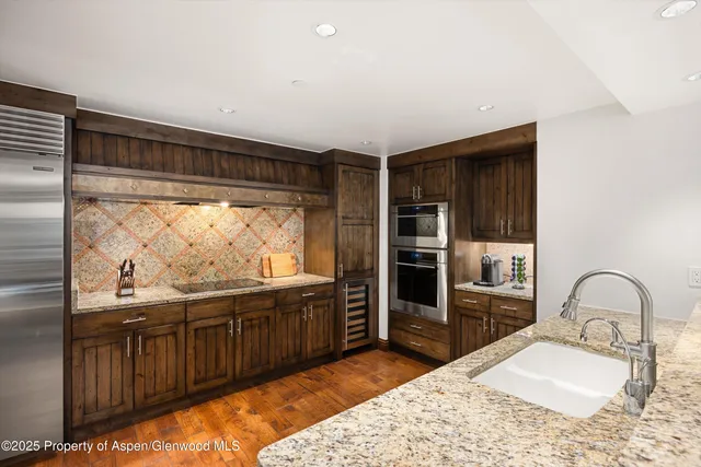 a kitchen with stainless steel appliances granite countertop a sink stove and refrigerator