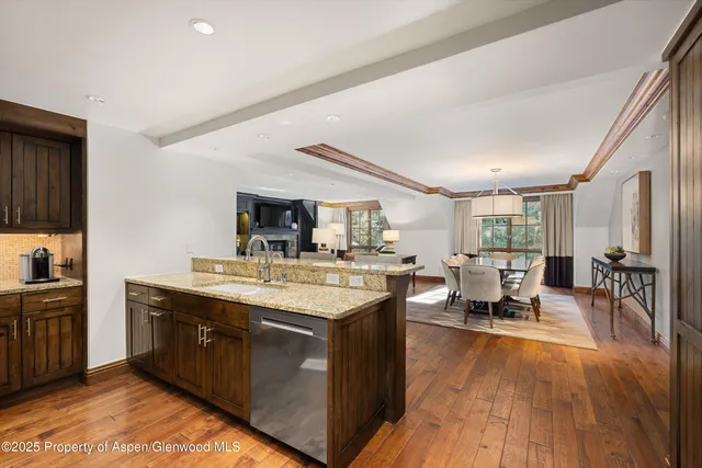 a living room with stainless steel appliances granite countertop furniture wooden floor and window