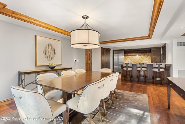 a view of a dining room with furniture a chandelier and wooden floor