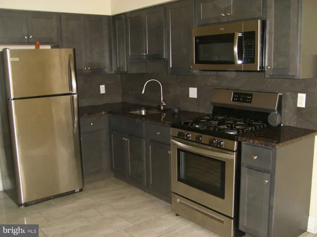 a kitchen with a refrigerator stove and cabinets