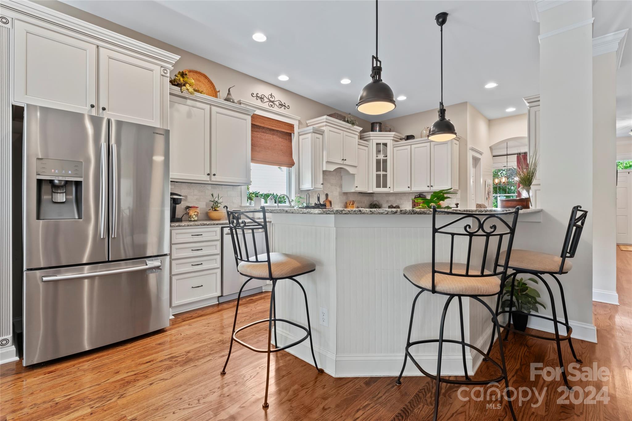 6059 Daphne Circle Fort Mill, SC 29708 - Photo 14 of 48 a kitchen with stainless steel appliances a refrigerator a stove a sink and chairs with wooden floor