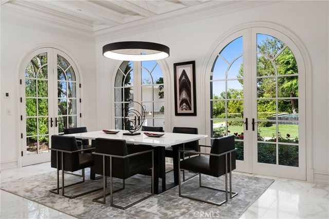 a kitchen with stainless steel appliances a stove a microwave a dining table and chairs with wooden floor