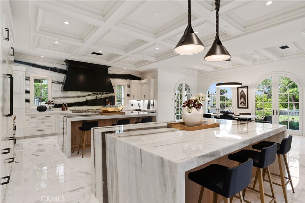 22 Deep Sea Newport Coast, CA 92657 - Photo 19 of 57 a kitchen with stainless steel appliances a stove a microwave a dining table and chairs with wooden floor