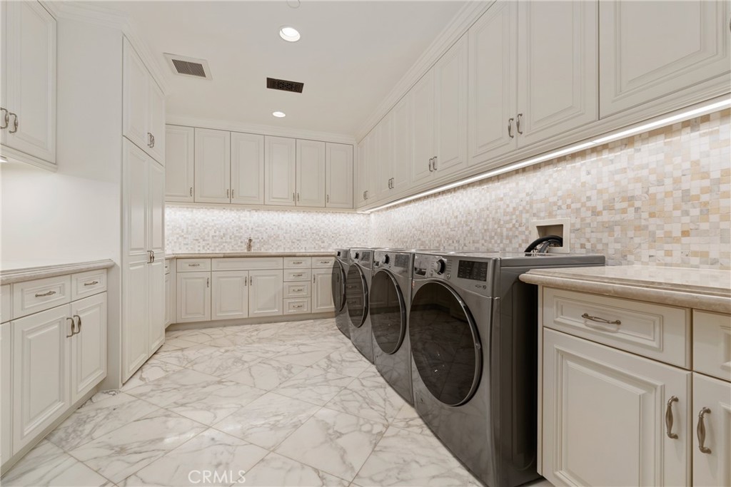 22 Deep Sea Newport Coast, CA 92657 - Photo 48 of 57 a utility room with cabinets washer and dryer
