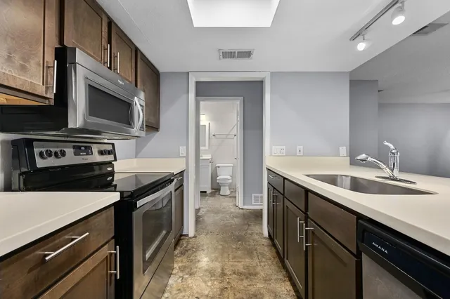 a kitchen with stainless steel appliances a sink and a refrigerator