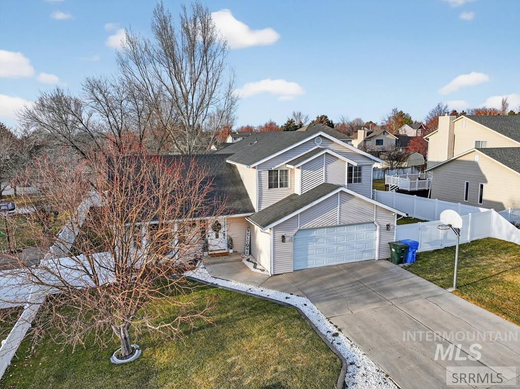 View of front of house with concrete driveway and a shingled roof