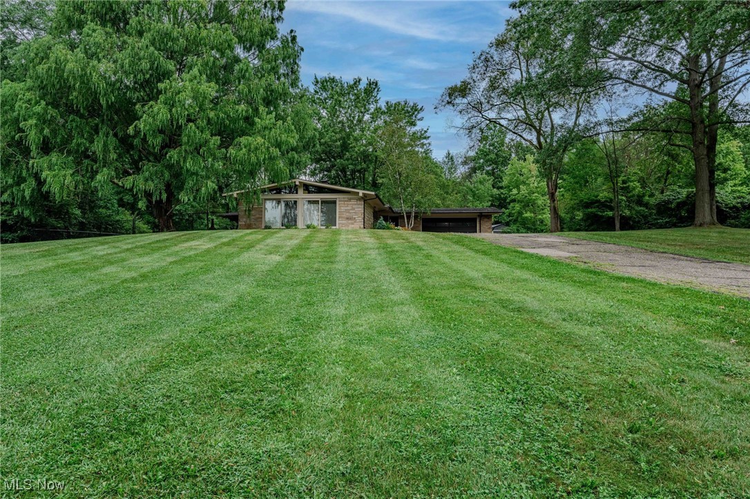 3381 Barrett Road Akron, OH 44333 - Photo 39 of 50 View of green lawn featuring dirt driveway and an attached garage