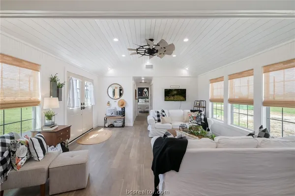 a living room with furniture large window and flat screen tv