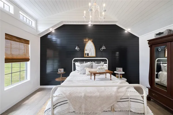 a bedroom with a bed and a chandelier