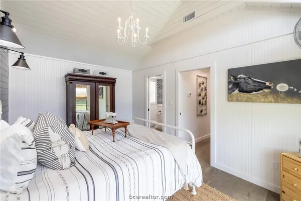 a bedroom with bed and a chandelier