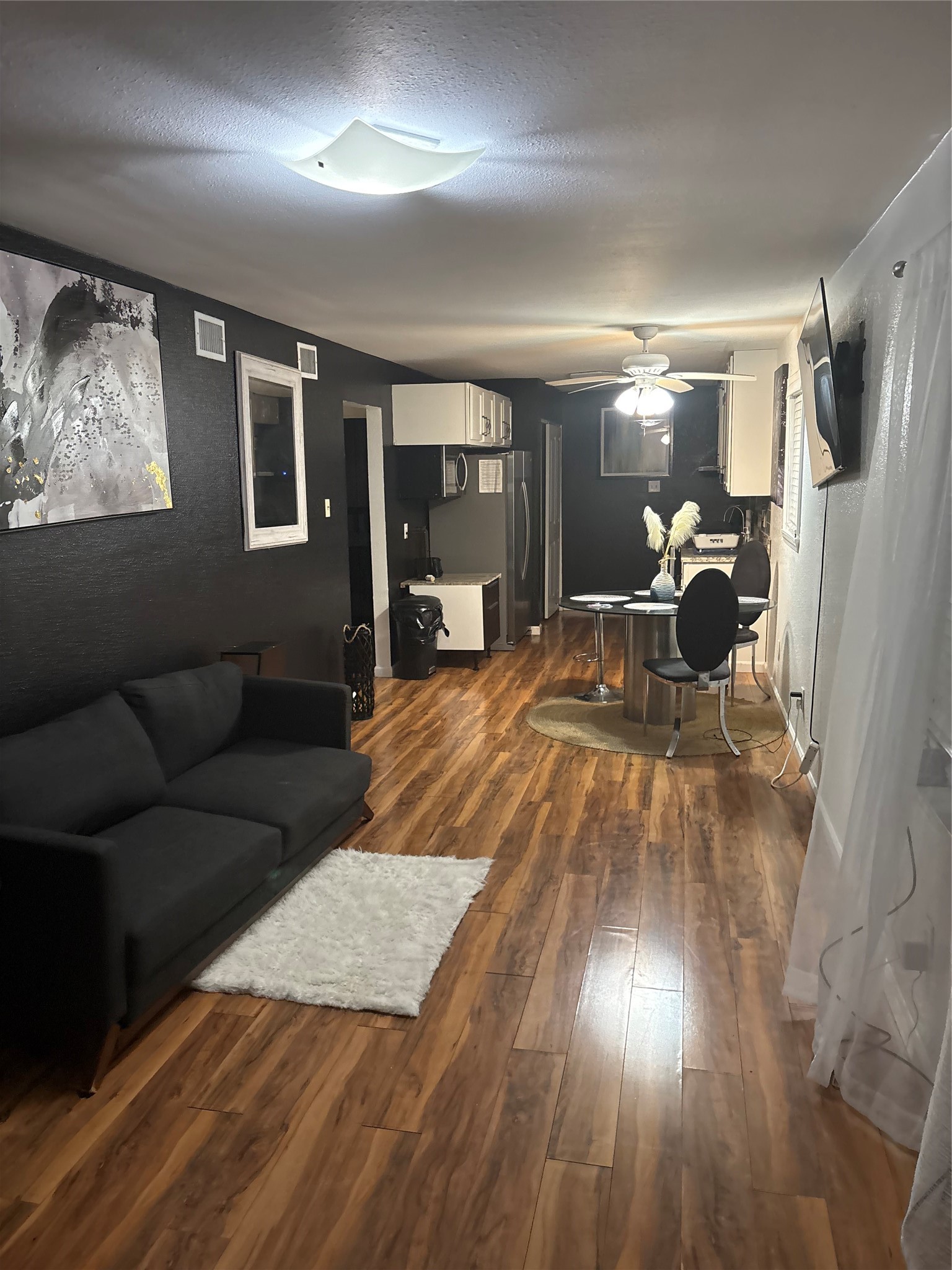 a living room with furniture and a wooden floor