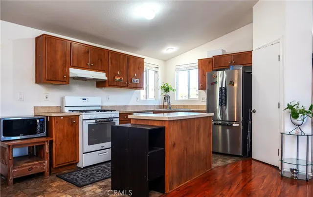 a kitchen with stainless steel appliances granite countertop a stove a refrigerator and a sink