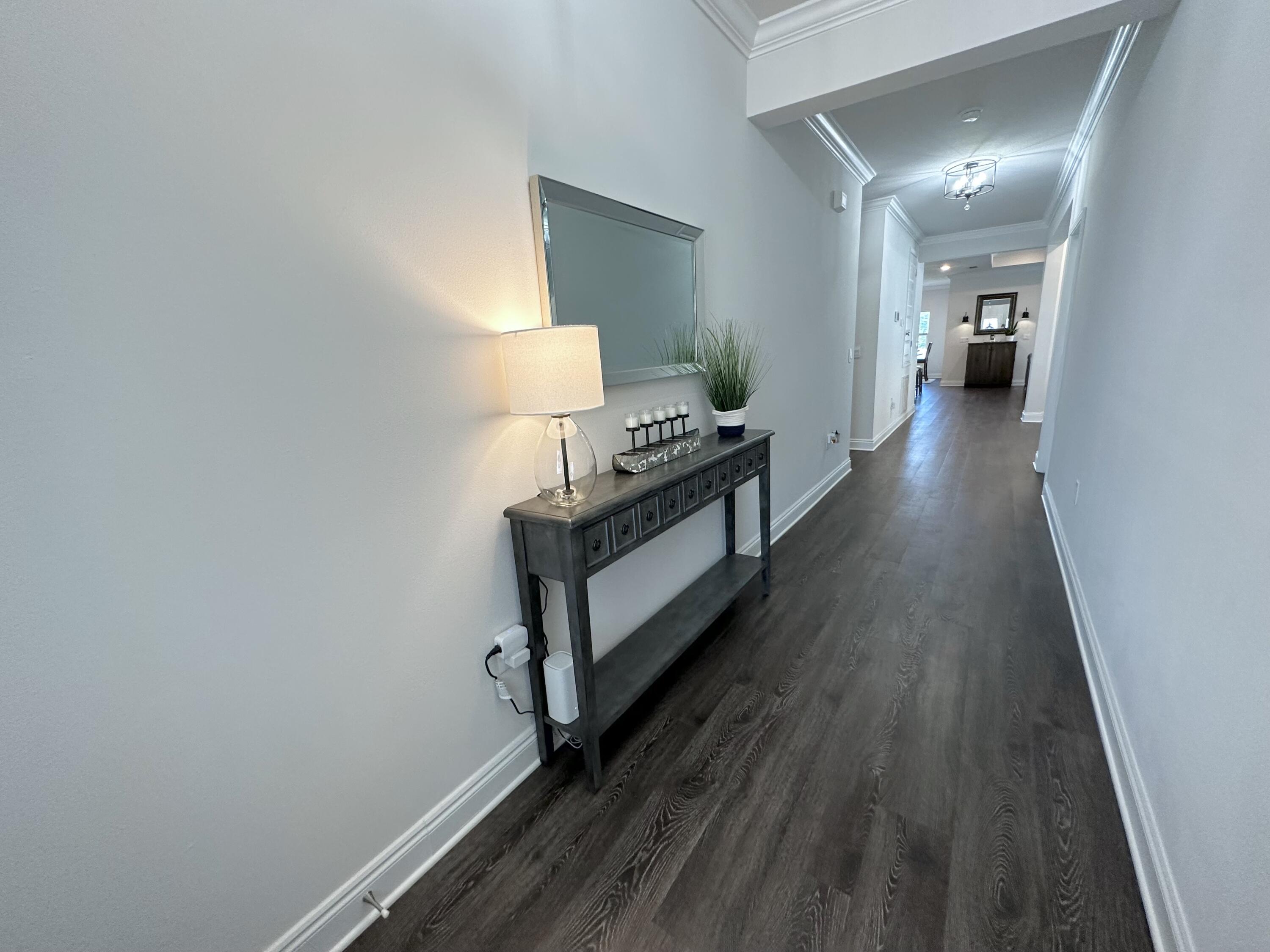 165 Martingale Loop Lynn Haven, FL 32444 - Photo 3 of 37 a view of a hallway with wooden floor and staircase