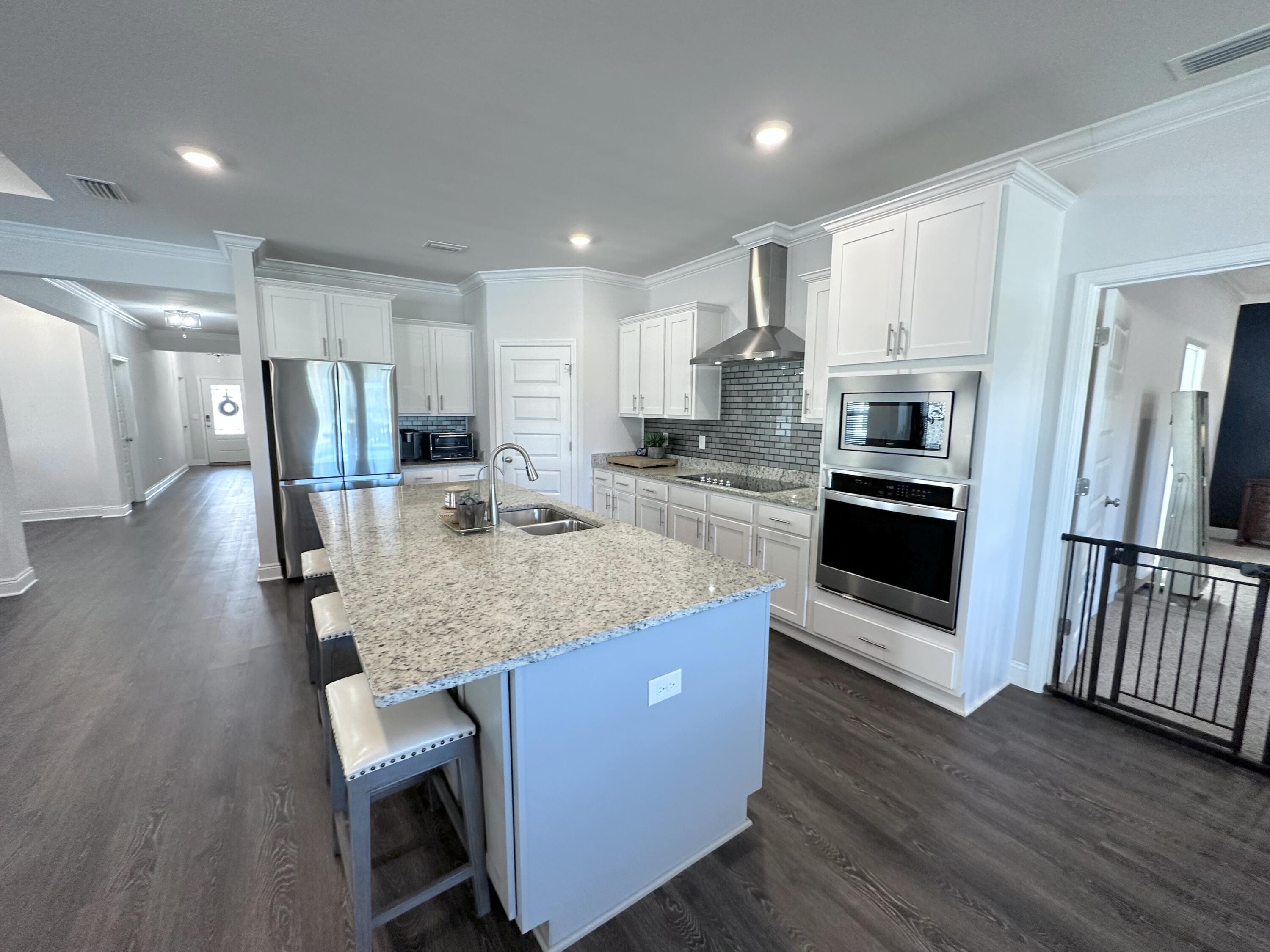 165 Martingale Loop Lynn Haven, FL 32444 - Photo 10 of 37 a kitchen with stainless steel appliances granite countertop a kitchen island hardwood floor and a sink