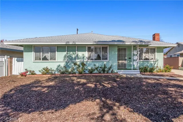 a front view of a house with a yard and potted plants