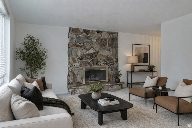 1722 Kimsbrough Road Sandy, UT 84092 - Photo 5 of 29 Living room featuring a stone-clad fireplace with a hearth, light-toned carpeting, and white painted walls