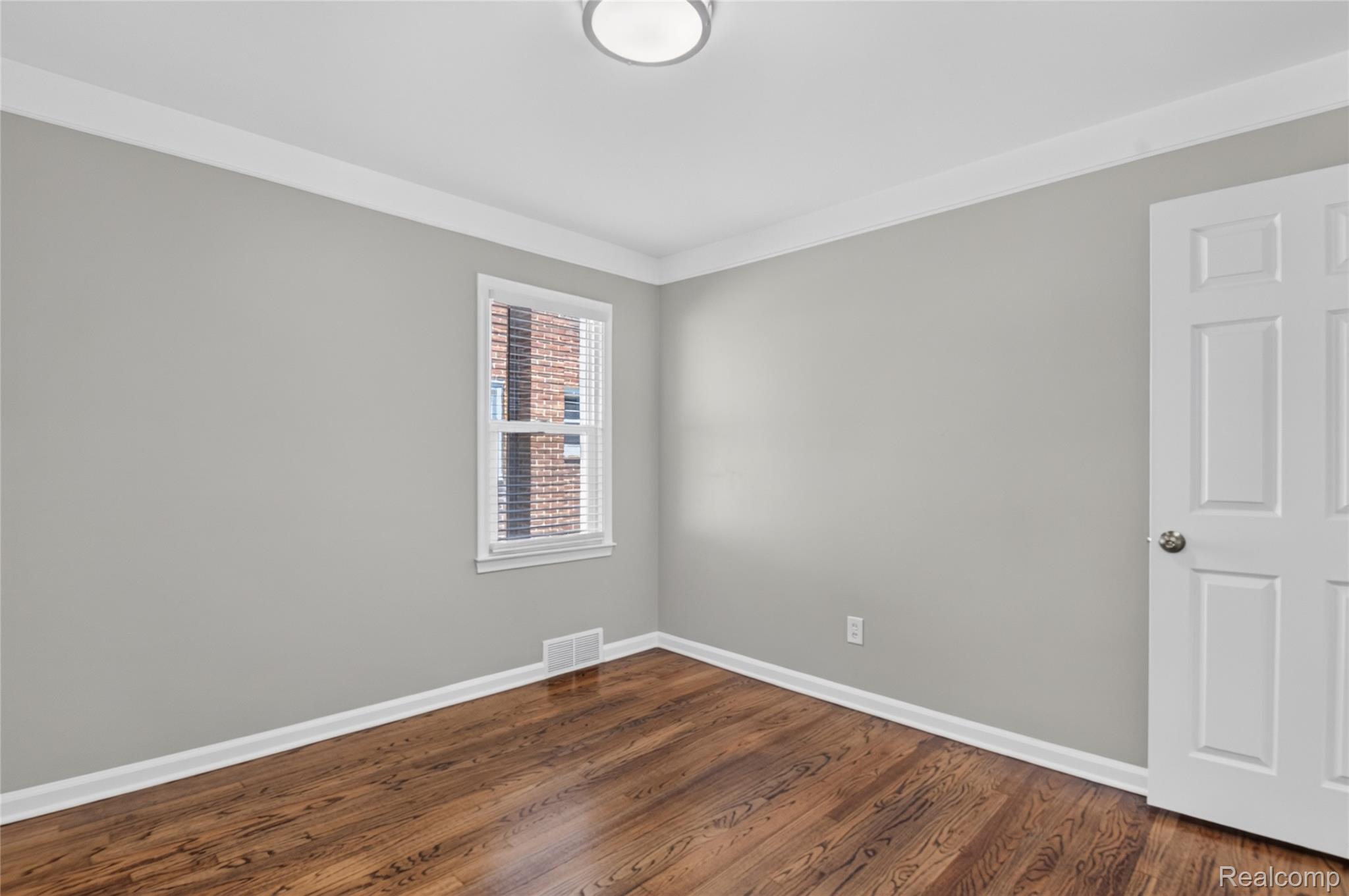 12972 Callender Street Southgate, MI 48195 - Photo 24 of 40 Bedroom featuring wood-finish flooring, a contemporary ceiling light fixture, white crown molding, and a white six-panel door
