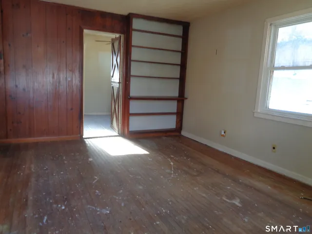 an empty room with windows and cabinet