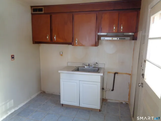 a kitchen with a sink cabinets and a window