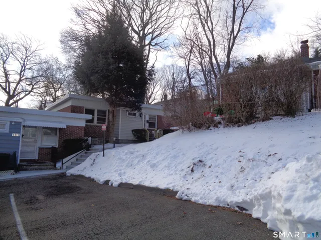 a front view of a house with a yard covered in snow