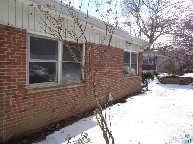 a view of a house with a yard covered in snow