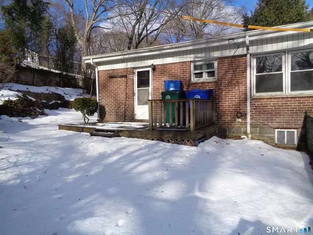 a view of a house with backyard and parking area