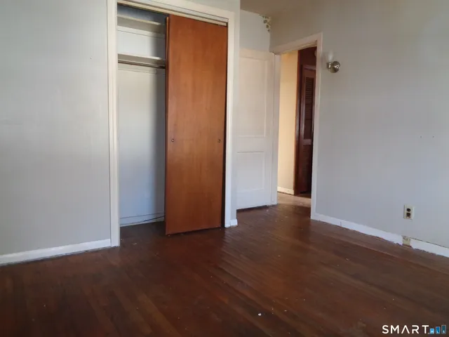 an empty room with wooden floor and closet