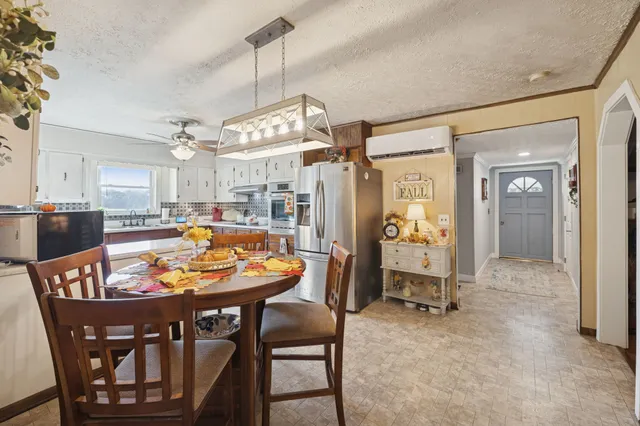 a dining room filled chandelier and wooden floor