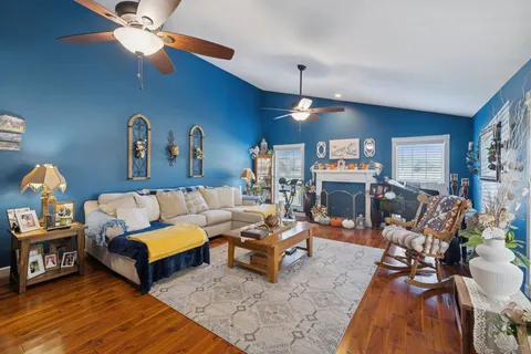 a living room with furniture a fireplace and a chandelier
