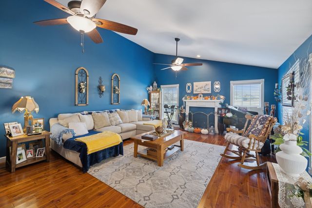 a living room with furniture a fireplace and a chandelier