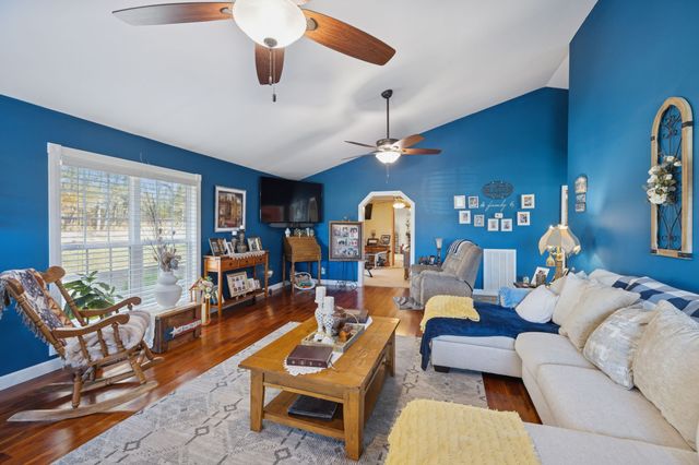 a living room with furniture kitchen view and a large window