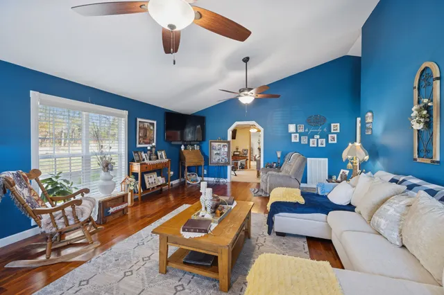 a living room with furniture kitchen view and a large window