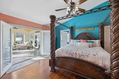 a bedroom with a bed wooden floor and window