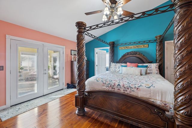a bedroom with a bed a chandelier and dresser
