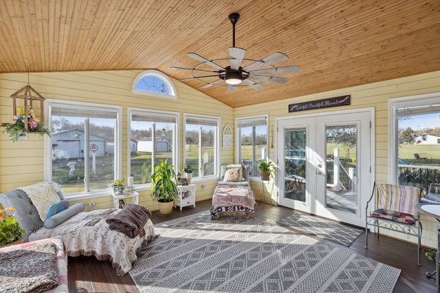 a living room with furniture ceiling fan and a large window