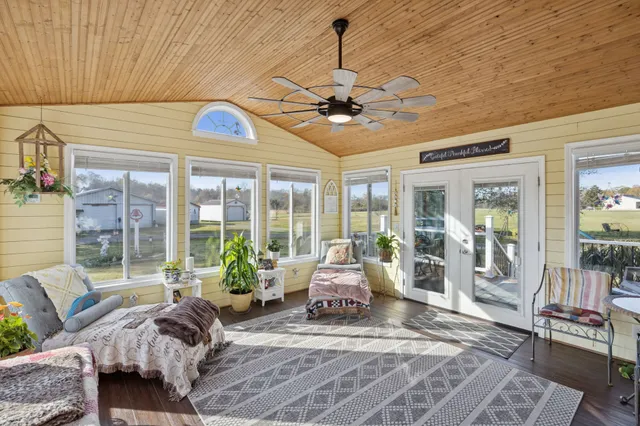 a living room with furniture ceiling fan and a large window