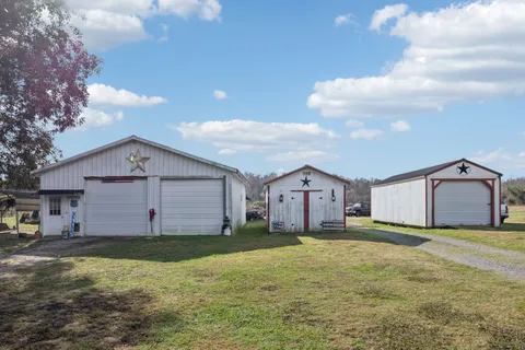 a view of a house with a big yard and large tree