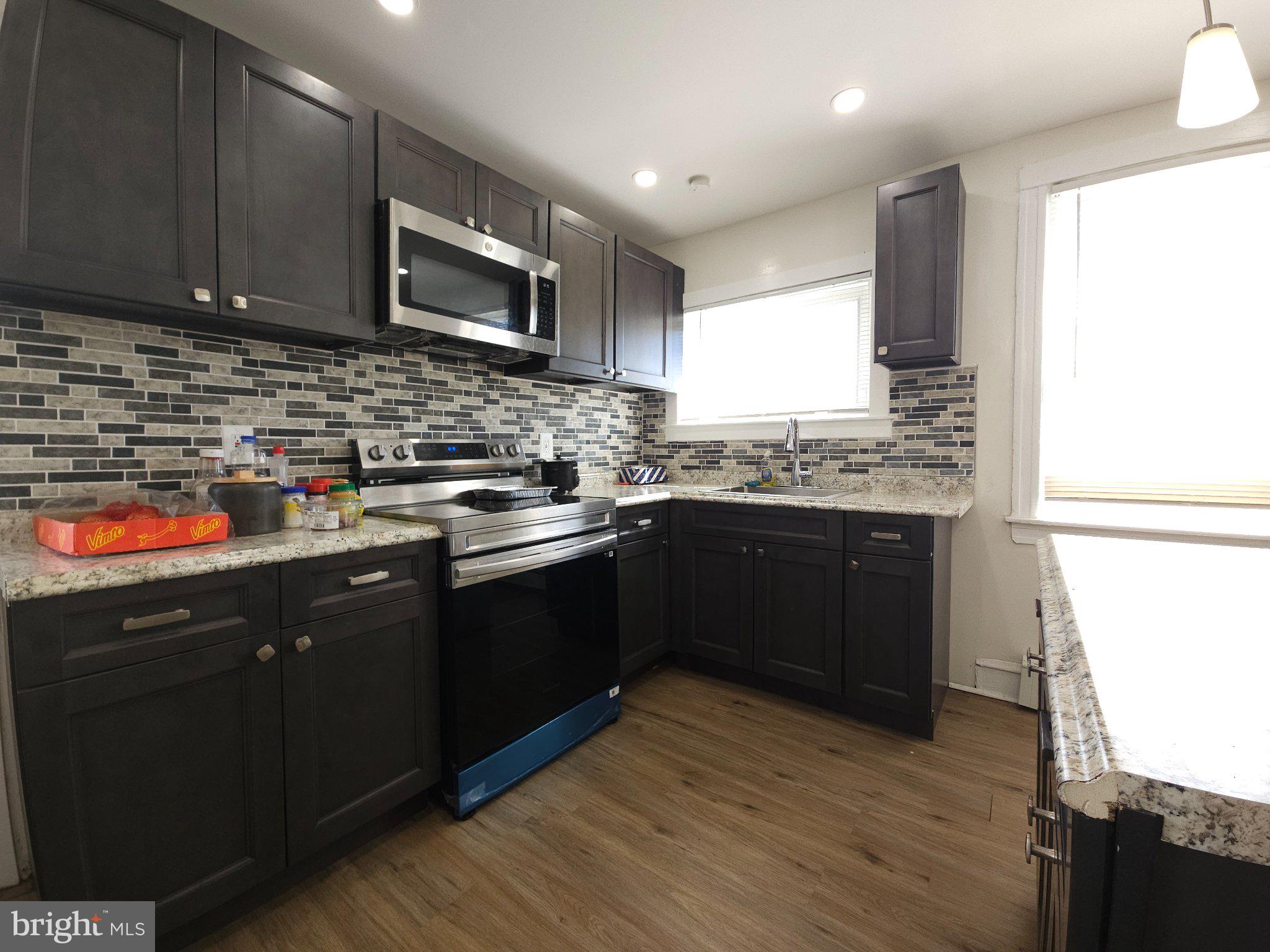 411 South Maple Avenue Lansdowne, PA 19050 - Photo 11 of 18 a kitchen with stainless steel appliances granite countertop wooden cabinets a refrigerator a sink a stove and a microwave