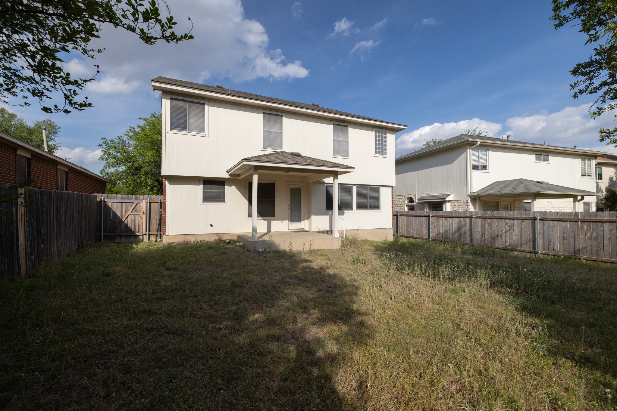 3410 Flowstone Lane Round Rock, TX 78681 - Photo 29 of 38 Spacious backyard with a covered patio, perfect for outdoor seating or entertaining. The two-story home features multiple windows for natural light, and the yard is fully fenced for added privacy.