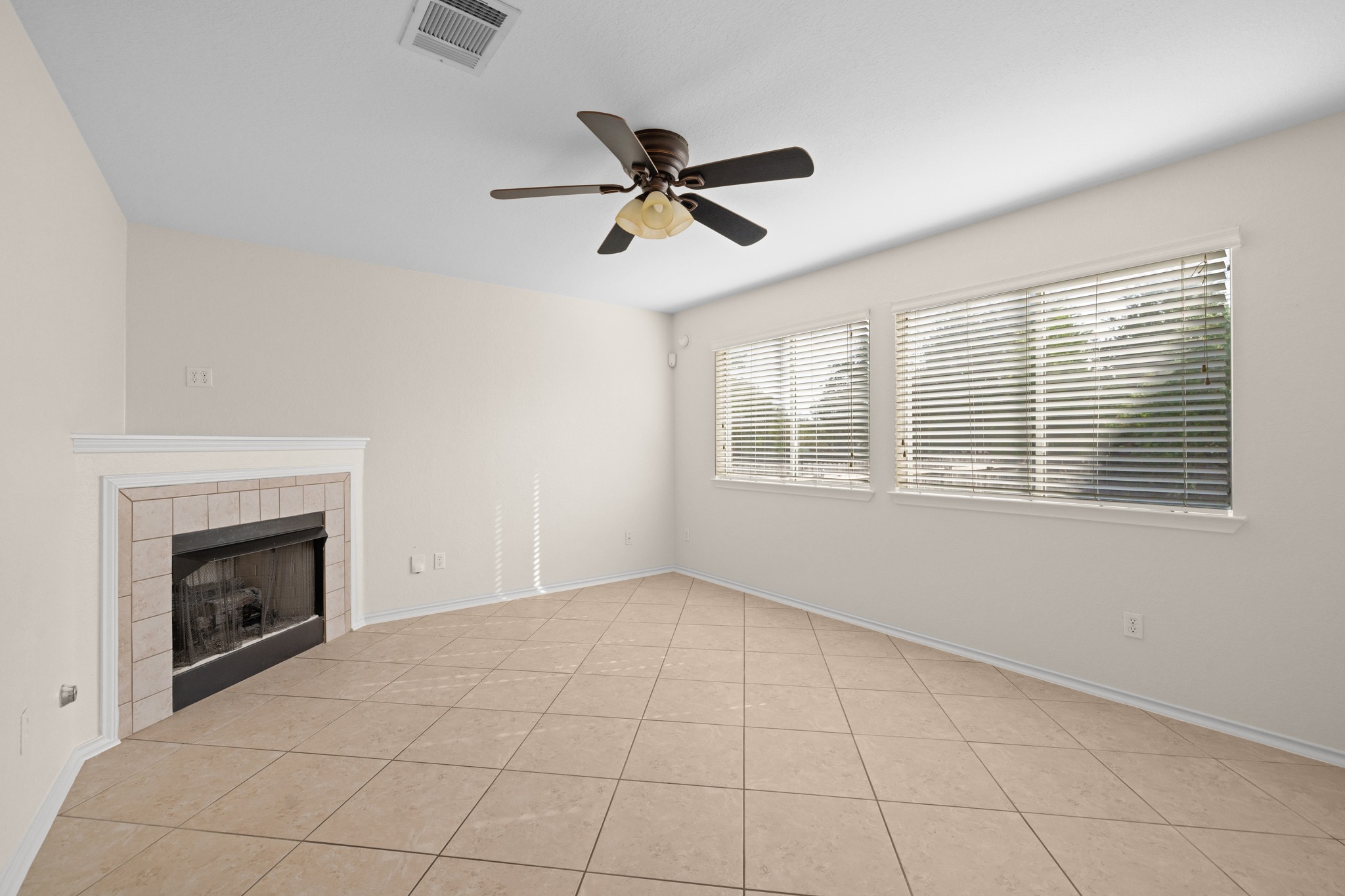 3410 Flowstone Lane Round Rock, TX 78681 - Photo 5 of 38 Comfortable living area with a fireplace, ceiling fan, and large windows that bring in natural light. Open layout makes it great for entertaining.