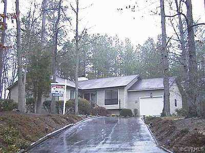 a front view of a house with a yard and trees